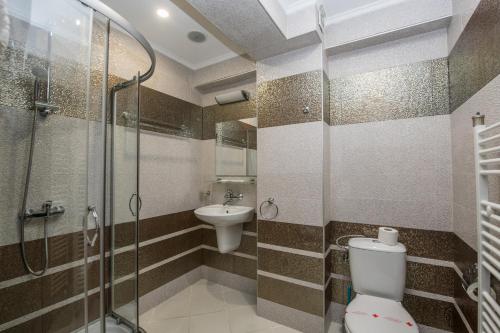 uma casa de banho com um chuveiro, um WC e um lavatório. em Complex Panorama em Elena