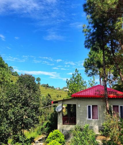 a small house with a red roof at Majkhali Woods, Ranikhet, By Himalayan Eco Lodges in Rānīkhet