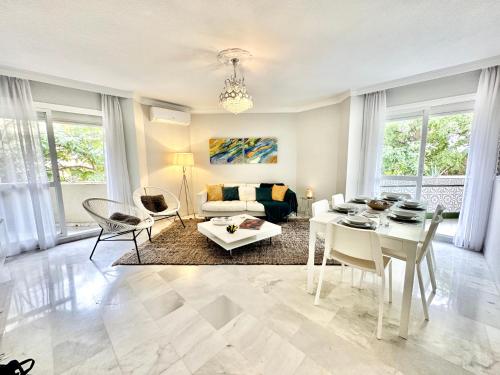 a living room with a white table and chairs at City Center Marbella Apartment - EaW Homes in Marbella