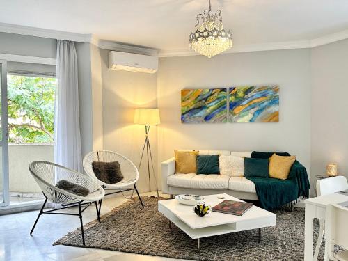 a living room with a couch and a table and chairs at City Center Marbella Apartment - EaW Homes in Marbella