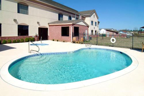 a swimming pool in front of a house at Comfort Suites Idabel in Idabel