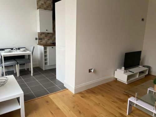 a small living room with a table and a television at City Centre 1 Bed Sleeps 4 H5 in Hull