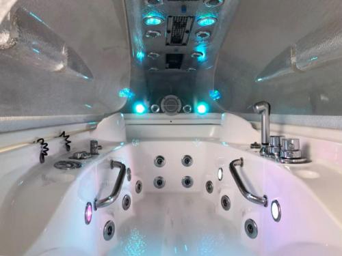 La salle de bains est pourvue d'une baignoire blanche avec des lumières bleues. dans l'établissement Grande Villa de 8 chambres avec Balnéothérapie- Vill'Acacia, à Bray-Dunes