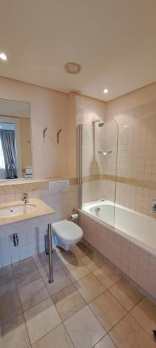 uma casa de banho com uma banheira, um WC e um lavatório. em V&A Waterfront Marina Family Apartment 201 Altmore Cape Town em Cidade do Cabo