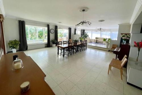 un grand salon avec une table et des chaises dans l'établissement Grande Villa de 8 chambres avec Balnéothérapie- Vill'Acacia, à Bray-Dunes