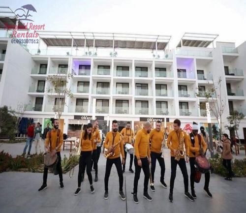 a group of men in yellow shirts standing in front of a building at شاليه للايجار اليومى بورتو سعيد in Port Said