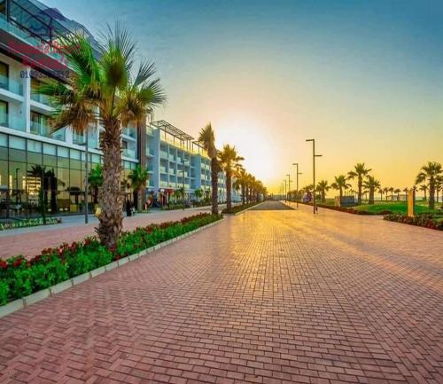 a brick road with palm trees and a building at شاليه للايجار اليومى بورتو سعيد in Port Said