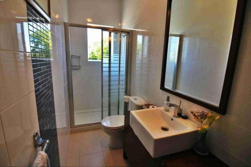 bagno con lavandino, servizi igienici e specchio di PRIVATE COUNTRY HOUSE 2000 MTRS LANZADA BEACH a Pontevedra
