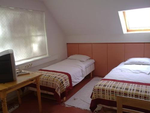 a room with two beds and a desk with a computer at Arno Apartments in Kuressaare