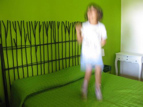 a young girl is jumping on a bed at Fattoria Bio L'A Ceccoli in Sassofeltrio
