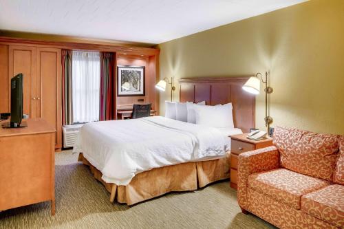 a hotel room with a bed and a couch at Wingate by Wyndham Cranberry in Cranberry Township