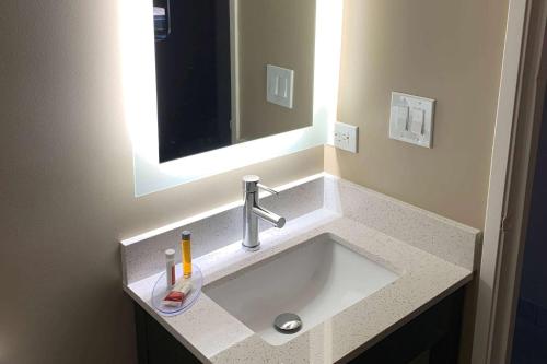 a bathroom with a sink with a mirror at Super 8 by Wyndham Joliet in Joliet