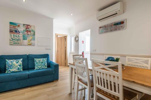 a living room with a blue couch and a table at Casa Mar d'Alma in Albufeira