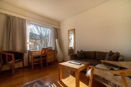 a living room with a couch and a table at Hotel Oslo Guldsmeden in Oslo