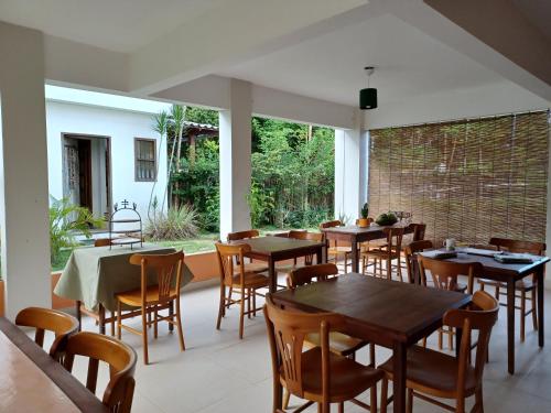 un restaurante con mesas y sillas en una habitación en Manjuba Pousada - Taipu de Fora, en Barra Grande