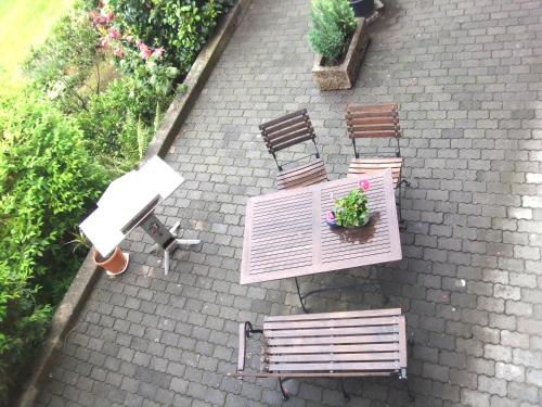 a patio with three benches and a table with a plant at Pension & Café Meine Sonne Sole Mio in Bad Sooden-Allendorf