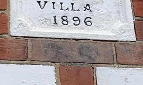 una señal en una pared de ladrillo con las palabras willemia en Smart & Comfortable 3-bedroom Victorian house, en Stalham