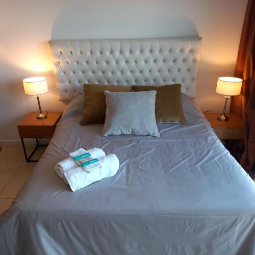 a bed with two towels on it with two lamps at Condominios W Nordelta Bahia,Tigre,Parking,Gym in Tigre