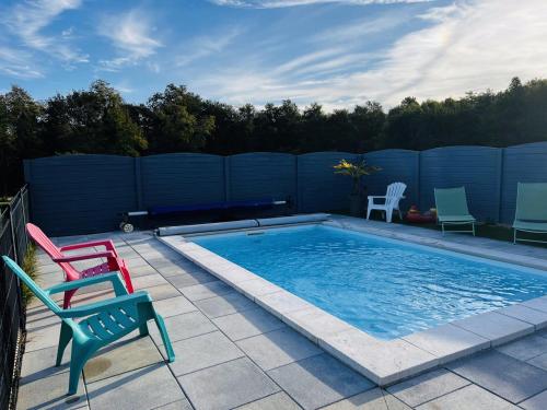 une piscine avec deux chaises et une clôture bleue dans l'établissement Les hauteurs de Beauval avec piscine à 1km du zoo, à Seigy