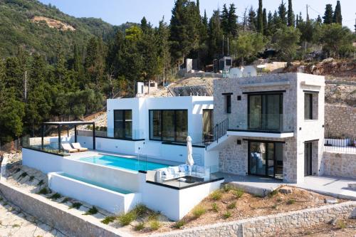 a house on a hill with a swimming pool at Mandevilla Hillside Luxury Villas in Agios Nikitas
