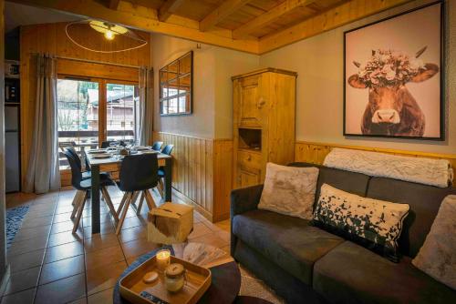 - un salon avec un canapé et une vache sur le mur dans l'établissement Appartement cosy aux Deux Alpes avec vue sur la montagne, à Les Deux Alpes