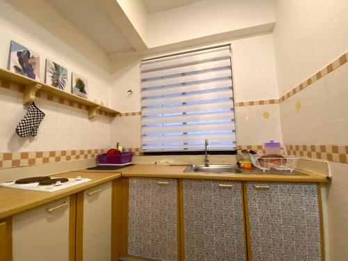 een keuken met een wastafel en een raam bij Lovly Couple Sea View w Netflix in Port Dickson