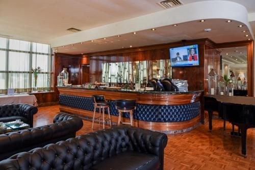 a bar with leather furniture and a flat screen tv at Hotel Leon d'Oro in Verona