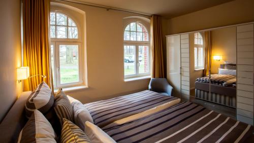 1 dormitorio con 1 cama y 2 ventanas en Parkresidenz Lychen, Ferienwohnung 1, en Lychen