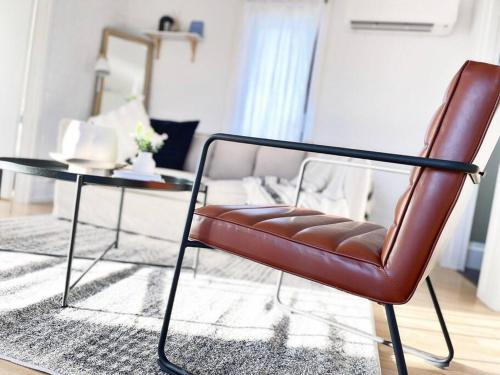 a leather chair and a table in a living room at The Shoreline - Absolute Beachfront 2BR Batehaven in Batehaven
