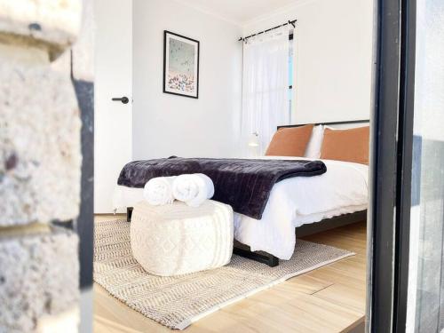 a bedroom with a bed and a table with towels on it at The Shoreline - Absolute Beachfront 2BR Batehaven in Batehaven