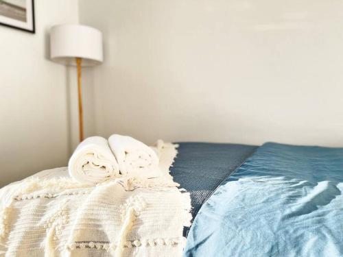 a bed with two towels on top of it at The Shoreline - Absolute Beachfront 2BR Batehaven in Batehaven