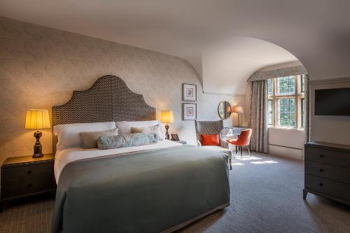una camera con un grande letto e una televisione di Horwood House Hotel a Milton Keynes