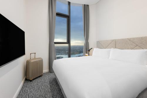 a hotel room with a bed and a window at Meriton Suites Surfers Paradise in Gold Coast