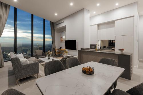a kitchen and living room with a table and chairs at Meriton Suites Surfers Paradise in Gold Coast