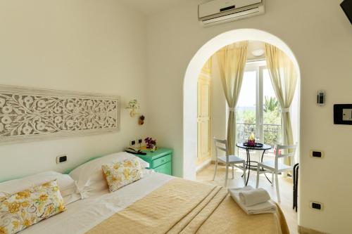 a bedroom with a bed and a table and a window at Hotel Ossidiana Stromboli Center in Stromboli