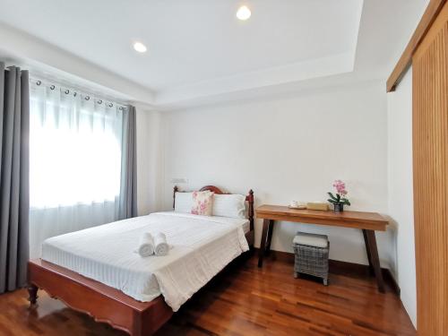 1 dormitorio con cama, escritorio y ventana en Sri Ayuttaya Guesthouse en Bangkok