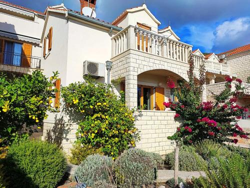 a large house with flowers on the stairs at Apartments Benika in Bol
