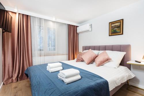 una camera da letto con un letto e asciugamani di City of the Kings-Old Town Pastel Apartment a Cracovia