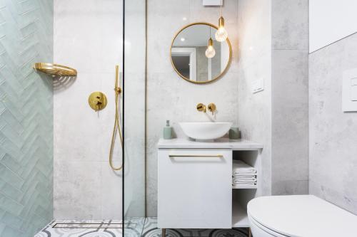 bagno con lavandino, servizi igienici e specchio di City of the Kings-Old Town Pastel Apartment a Cracovia
