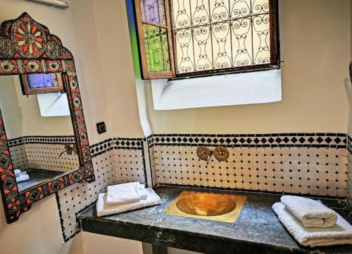 La salle de bains est pourvue d'un lavabo et d'un miroir. dans l'établissement Room in old house, à Oulad Akkou