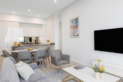 a living room with a couch and a table with chairs at Meriton Suites Surfers Paradise in Gold Coast