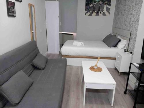 マドリードにあるApartamento en el corazón de Madridの小さなリビングルーム(ベッド2台、ソファ付)