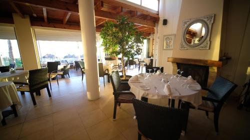uma sala de jantar com mesas e cadeiras e uma lareira em Apartamentos Coronado em Marbella