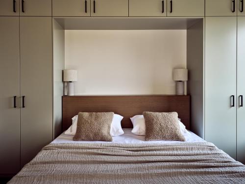 a bedroom with a large bed with two pillows at Zayn Luxury Villas, a Serene Escape, By ThinkVilla in Zakynthos Town