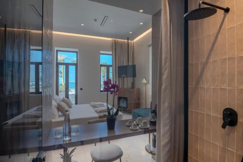 a hotel room with a bed and a mirror at Omma Suites in Rethymno Town
