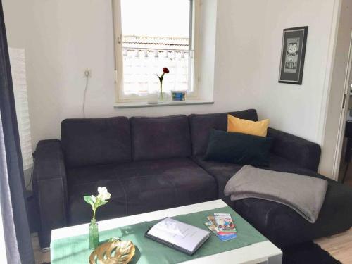 a living room with a black couch and a table at Mainroom Kitzingen in Kitzingen