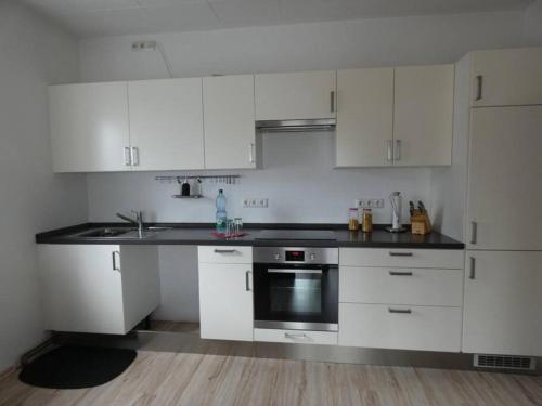 a kitchen with white cabinets and a black counter top at Mainroom Kitzingen in Kitzingen