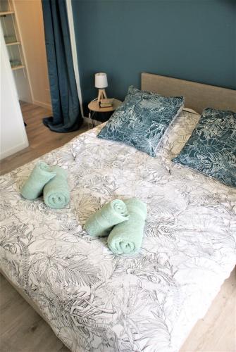 un lit avec deux serviettes et des oreillers dessus dans l'établissement Le coquet de Rompsay Paisible & Moderne, à La Rochelle