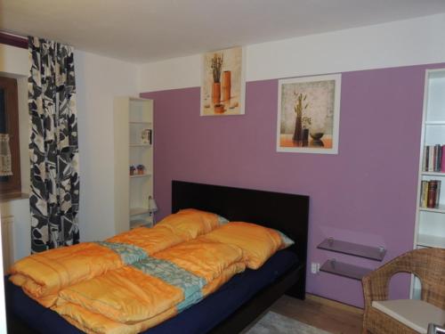 1 dormitorio con 1 cama con manta naranja en Ostseeoase, en Ratekau