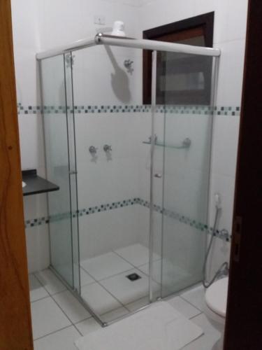 a glass shower in a bathroom with a toilet at Residencial Seestern - Suítes in Cananéia